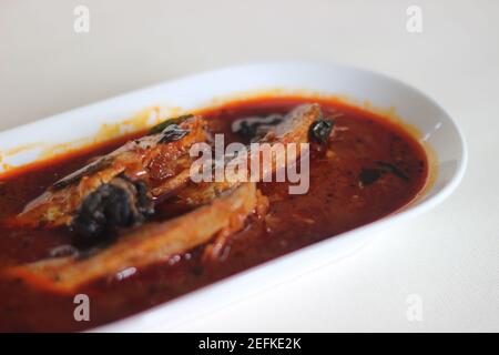 Il curry di sardine è un curry centrale tradizionale del Kerala anche conosciuto come curry di mathi. Scatto su sfondo bianco. Foto Stock