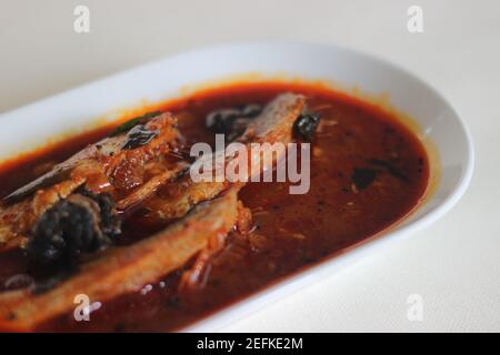 Il curry di sardine è un curry centrale tradizionale del Kerala anche conosciuto come curry di mathi. Scatto su sfondo bianco. Foto Stock