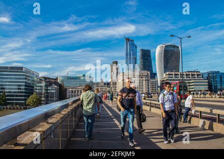 2019 07 24 London UK - i pedoni che attraversano il London Bridge con la Skyline di Londra in lontananza in una bella giornata. Foto Stock
