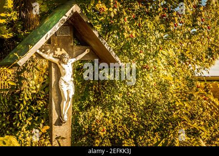 Wayside croce con in Baviera accanto ad un albero in autunno Foto Stock