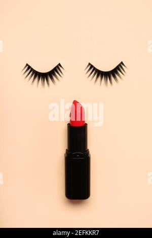 False ciglia e rossetto rosso su un beige background.Beauty e. concetto di trucco Foto Stock