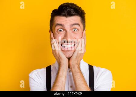 Ritratto di divertente simpatico ragazzo allegro che indossa camicia bianca incredibile news reaction isolato su sfondo giallo brillante Foto Stock