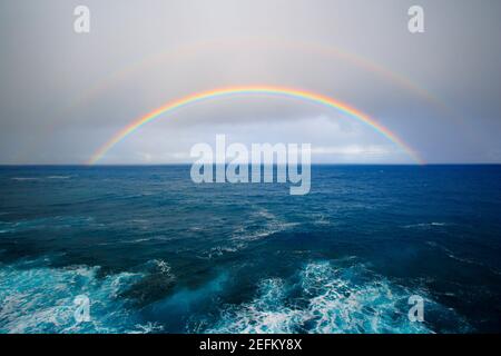 Il doppio arcobaleno appare sull'Oceano Pacifico al crepuscolo a Big Island Hawaii USA. Foto Stock