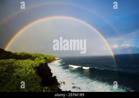 Il doppio arcobaleno appare sopra l'Oceano Pacifico nel crepuscolo Hawaii USA. Foto Stock