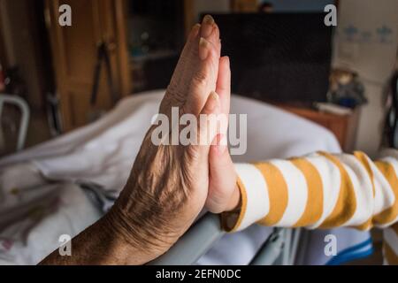 nipote che tiene la mano della nonna malata Foto Stock