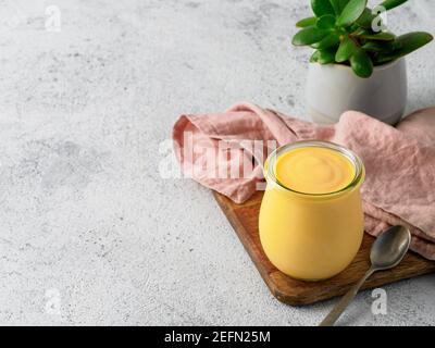 Giallo mango lassi su sfondo grigio. Indian Mango yogurt drink con copia spazio a sinistra. Foto Stock