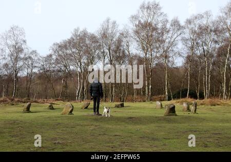 L'uomo e il suo cane a Nine Ladies Stone Circle on Stanton Moor nel Derbyshire Peak District Foto Stock