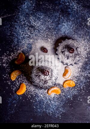 muffin al cioccolato cosparsi di dolci con ciliegie e cioccolato e. cacao Foto Stock