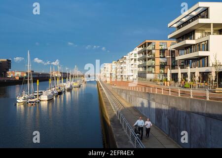 Coppia con bicicletta Uebrseestadt , Città anseatica di Brema, Germania Foto Stock