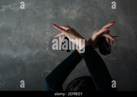 Giovane adulta spagnola donna danzante flamenco con castaneti su grigio sfondo di uno studio d'epoca Foto Stock