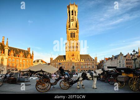 Piazza principale di Bruges con carrozze trainate da cavalli, Fiandre, Belgio Foto Stock