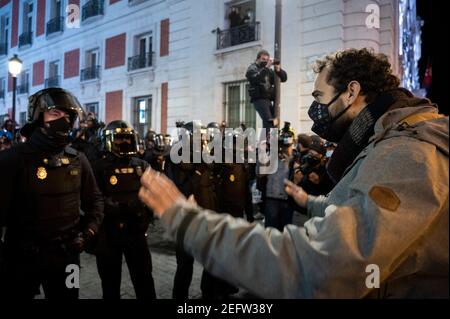 Madrid, Spagna. 17 Feb 2021. Un protetore che si trova di fronte alla polizia durante una manifestazione contro l'incarcerazione del rapper spagnolo Pablo Hasel per alcuni testi e tweet di canzoni che criticano la monarchia spagnola. Credit: Marcos del Mazo/Alamy Live News Foto Stock