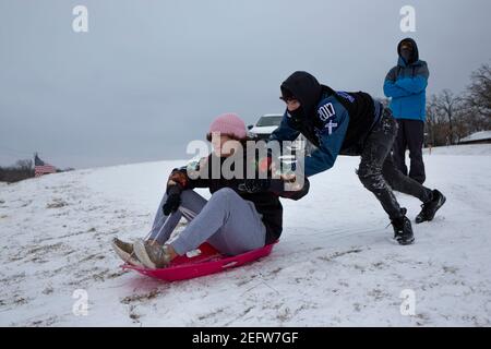 Fiore Mound, Texas, Stati Uniti. 17 Feb 2021. 2/17/21, Flower Mound, Texas - i texani hanno trovato il modo di trasformare questa tempesta invernale in un'esperienza divertente. Un gruppo di adolescenti trascorre la serata in slitta con i loro amici. Credit: Chris Rusanowsky/ZUMA Wire/Alamy Live News Foto Stock