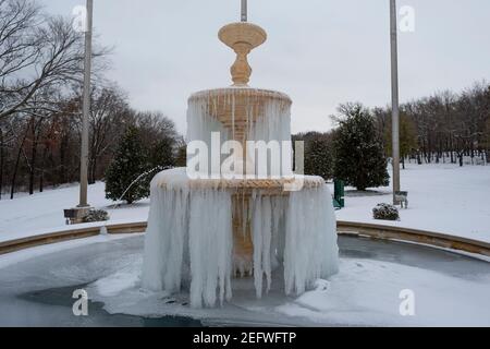 Fiore Mound, Texas, Stati Uniti. 17 Feb 2021. Una fontana è congelata a causa della gigantesca tempesta di neve che ha colpito il Texas del Nord negli ultimi due giorni. È stata posta un'ordinanza sull'EBOLLIZIONE a livello di città per informare il residente che l'acqua deve essere bollita prima dell'uso a causa dell'approvvigionamento idrico dei batteri. Credit: Chris Rusanowsky/ZUMA Wire/Alamy Live News Foto Stock