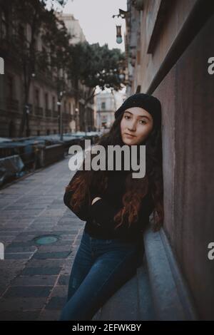 Giovane ragazza vestita con abiti caldi in posa per la foto Su una strada a Città del Messico Foto Stock