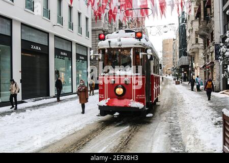 Istanbul, Turchia. 17 Feb 2021. Lo storico tram corre lungo la strada innevata sulla famosa via Istiklal di Istanbul. Credit: SOPA Images Limited/Alamy Live News Foto Stock
