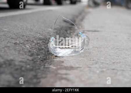 Uno scudo protettivo in plastica gettato per la strada. Foto Stock