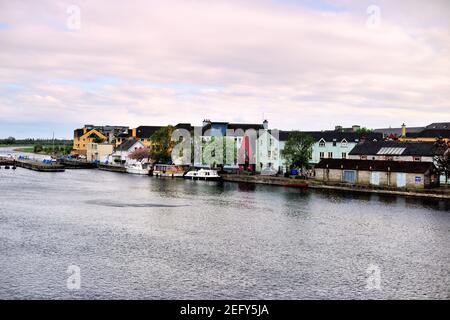 Athlone, Contea di Westmeath, Irlanda. Barche legate nel fiume Shannon lungo case e edifici in ordine. Foto Stock