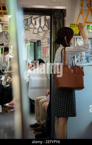 La lavoratrice d'ufficio donna si trova sulla metropolitana a Tokyo, Giappone Foto Stock