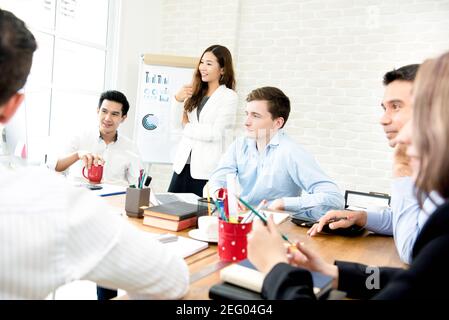 Giovani uomini d'affari interrazziali che ascoltano il loro collega nel meeting - lavoro di squadra e concetti di brainstorming Foto Stock