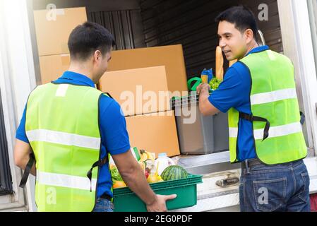 Uomini di consegna che prendono il cibo dalla macchina circa a. consegna Foto Stock