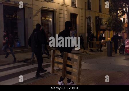 Madrid, Spagna. 17 Feb 2021. Diversi manifestanti affrontano la polizia con vari oggetti. (Foto di Fer Capdepon Arroyo/Pacific Press) Credit: Pacific Press Media Production Corp./Alamy Live News Foto Stock