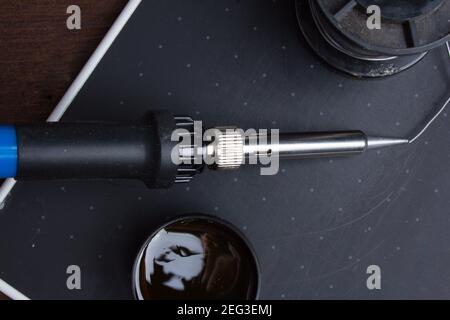 Utensili di saldatura. Saldatore e colofonia su sfondo nero Foto Stock