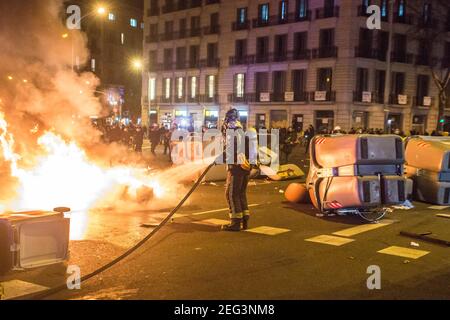 Barcellona, Catalogna, Spagna. 17 Feb 2021. I vigili del fuoco hanno visto spegnere gli incendi dei contenitori dei rifiuti.seconda notte di manifestazioni, a Barcellona, per la prigione del rapper catalano, Pablo Hasél, arrestata martedì 16 febbraio e condannata a nove mesi e un giorno in carcere dalla Camera d'appello della Corte nazionale nel settembre 2018, oltre al pagamento di una multa di circa 30,000 euro accusati di glorificare il terrorismo, insultare e calunniare la monarchia e le forze di sicurezza dello stato. Credit: Thiago Prudencio/DAX/ZUMA Wire/Alamy Live News Foto Stock