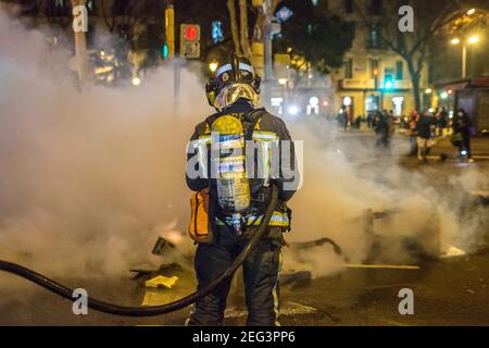 Barcellona, Catalogna, Spagna. 17 Feb 2021. I vigili del fuoco hanno visto spegnere gli incendi dei contenitori dei rifiuti.seconda notte di manifestazioni, a Barcellona, per la prigione del rapper catalano, Pablo Hasél, arrestata martedì 16 febbraio e condannata a nove mesi e un giorno in carcere dalla Camera d'appello della Corte nazionale nel settembre 2018, oltre al pagamento di una multa di circa 30,000 euro accusati di glorificare il terrorismo, insultare e calunniare la monarchia e le forze di sicurezza dello stato. Credit: Thiago Prudencio/DAX/ZUMA Wire/Alamy Live News Foto Stock