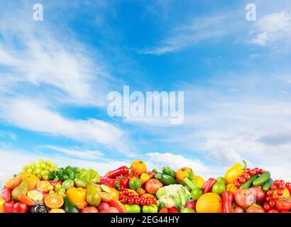 Foto panoramica frutta e verdura su sfondo blu cielo chiaro. Foto Stock
