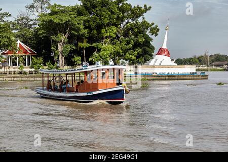 Un traghetto passa di fronte al lato lop Mu Tao Chedi. Il chedi fa parte di Wat Paramaiyikawas, all'angolo nord-est di Ko Kret. È affondato a causa di la Foto Stock