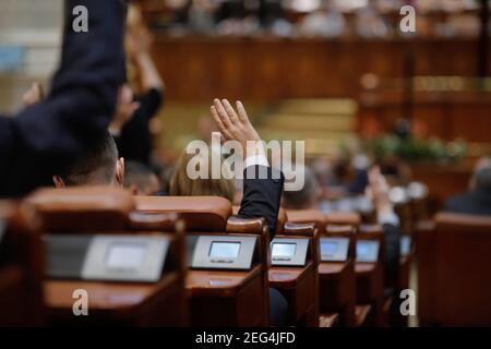 Bucarest, Romania - 17 febbraio 2021: Profondità di campo poco profonda (fuoco selettivo) con i dettagli del voto dei parlamentari rumeni alzando le mani. Foto Stock