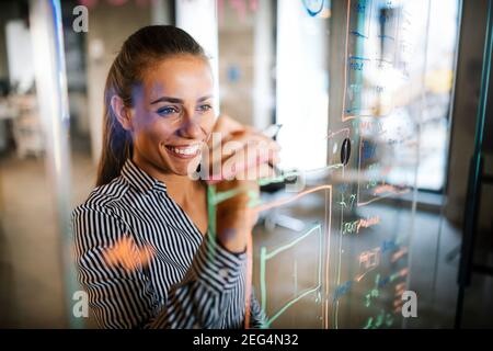 Felice donna che lavora, brainstorming in ufficio. Vaiolando nuove idee Foto Stock