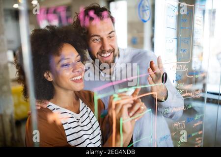 Felice di giovani uomini di affari che colleghi parlare lavoro in ufficio Foto Stock