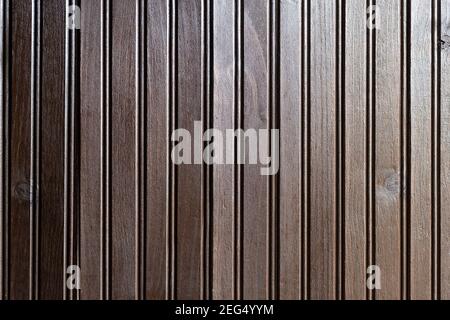 Una superficie di legno scuro formata da assi stretti in posizione verticale. Entra luce laterale. Sfondo per inviti o schede. Foto Stock