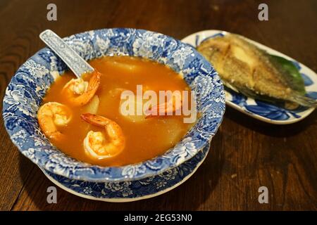 Zuppa di curry acida di gamberi servita con Gourami fritti (Gouramy) pesce Foto Stock