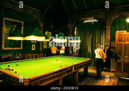 Cragside Biliardo sala Northumberland UK gioco da tavolo luci a bassa illuminazione foto arte tappeto giocatori tende tenda verde palla rossa snooker gioco Foto Stock