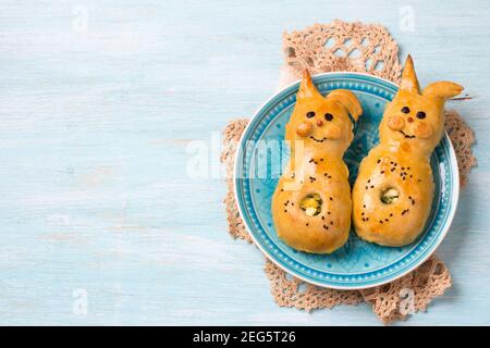 Polpettine con cipolle verdi e uova, in forma di coniglio su sfondo azzurro, spazio libero. Deliziosa cottura fatta in casa di Pasqua Foto Stock