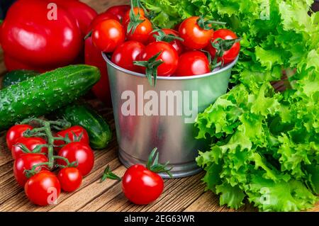 Set di verdure per insalata, cetrioli, peperoni, pomodori ciliegini rossi freschi su un tavolo di legno top.vista dall'alto. Vendemmia. Cibo naturale. Foto Stock