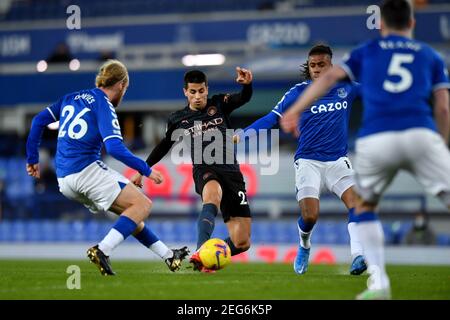 Liverpool, Regno Unito, 17 febbraio 2021. Nella foto da sinistra a destra, Tom Davies di Everton e Joao Cancelo di Manchester City in azione. Credit: Anthony Devlin/Alamy Live News Foto Stock