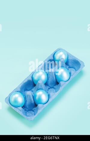 Cinque uova di colore blu perla nel vassoio blu del mercato del cartone, concetto moderno di pasqua alla moda Foto Stock