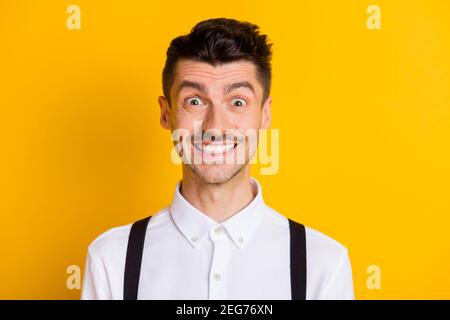 Primo piano ritratto di simpatico simpatico ragazzo allegro che indossa una camicia bianca sorridente isolato su uno sfondo di colore giallo brillante Foto Stock