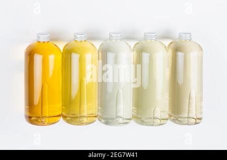 Bottiglie di raccolta trasparenti con diversi colori chiari olio cosmetico liquido, bolla e tappo argentato su sfondo bianco, mockup, vista dall'alto. Foto Stock