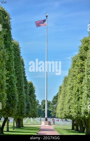 NORMANDIA, FRANCIA - 5 luglio 2017: Grande bandiera degli Stati Uniti e turisti in visita 'il Giardino della scomparsa' al cimitero americano della battaglia di Foto Stock