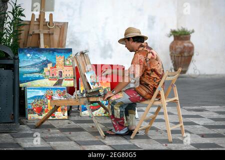 Artista di strada e pittore in un mercato di strada in un vicolo nel centro storico di Taormina in provincia di Sicilia in Italia. Italia, Sicilia, Foto Stock