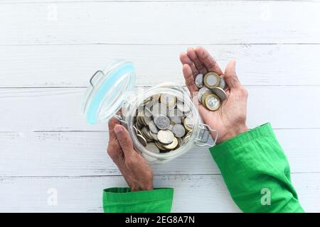 le donne anziane salvano le monete in un vaso, in alto verso il basso Foto Stock