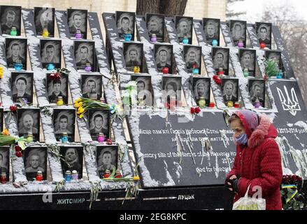 Kiev, Ucraina. 18 Feb 2021. Una donna guarda su un memoriale in memoria dei cento Celeste, attivisti che sono stati uccisi durante le proteste anti-governative del 2014, il 7° anniversario di Euro Maidan, a Kiev, Ucraina, il 18 febbraio 2021. Credit: Serg Glovny/ZUMA Wire/Alamy Live News Foto Stock