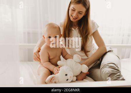 felice amorevole famiglia. mamma gioca con il suo bambino in camera da letto Foto Stock