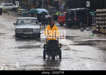 Gaza, Palestina. 18 Feb 2021. Un uomo palestinese spinge un carro mentre la pioggia cade nella città di Gaza, il 18 febbraio 2021. (Foto di Mahmoud Khattab/INA Photo Agency/Sipa USA) Credit: Sipa USA/Alamy Live News Foto Stock