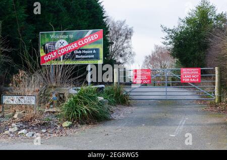 Caerwys, Flintshire; Regno Unito: 11 febbraio 2021: L'ingresso ad un campo da golf che un segno dichiara è chiuso. Un cancello ha cartelli di avvertimento di proprietà privata da tenere Foto Stock